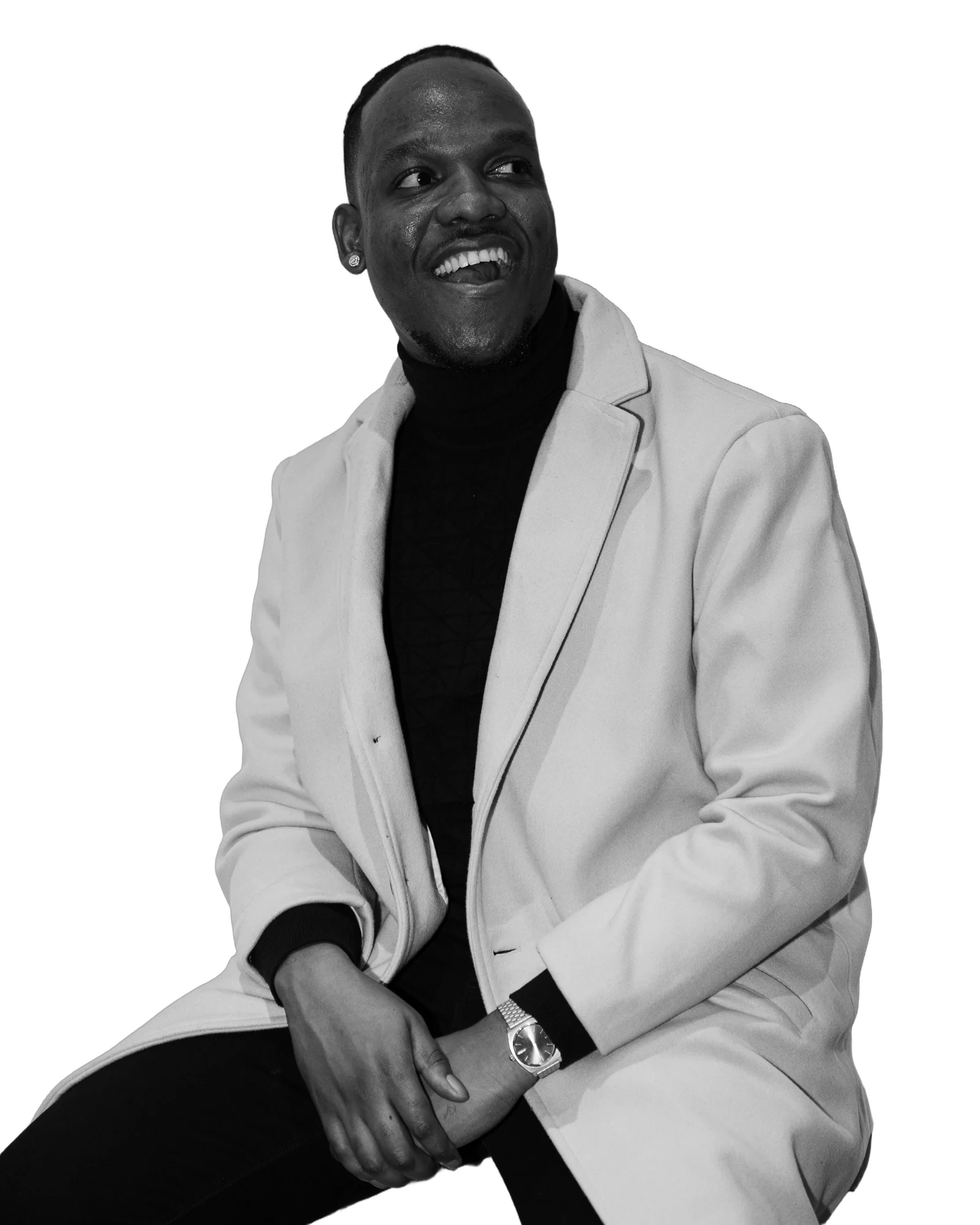 Jah Brown, smiling, in a light coat and black roll-neck